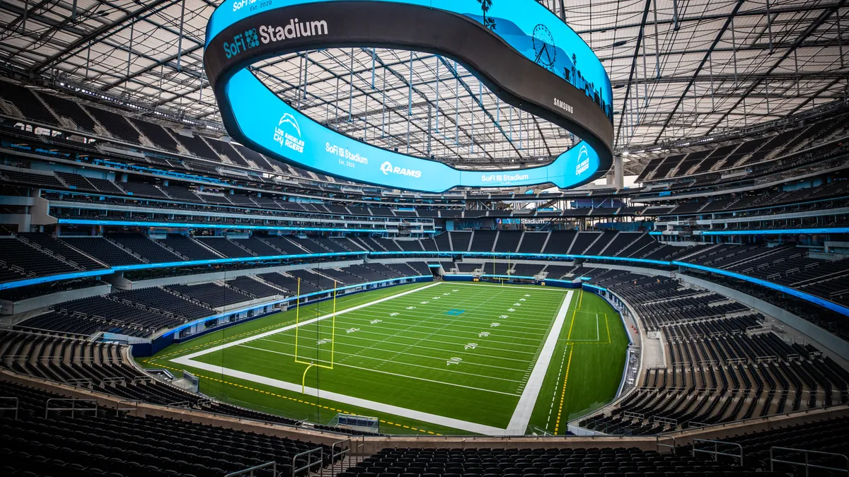 Interior of football stadium with large, ring-shaped video board.