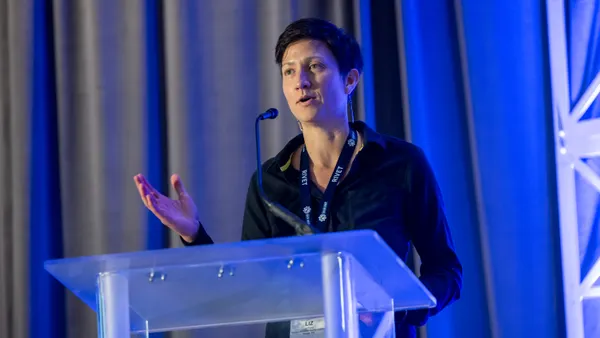 A woman gives a speech at a lectern