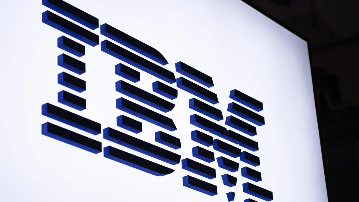 An illuminated sign with the IBM logo in blue on a white background.