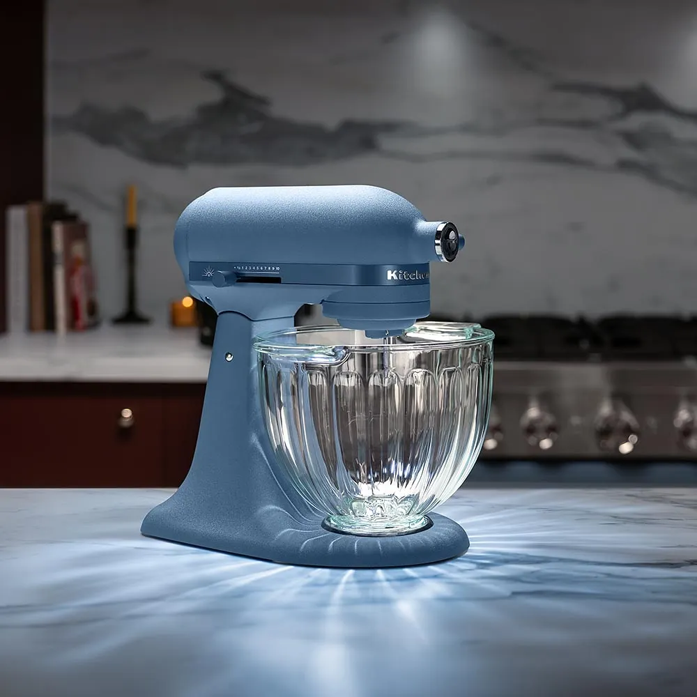 A light blue KitchenAid stand mixer with a glass bowl.