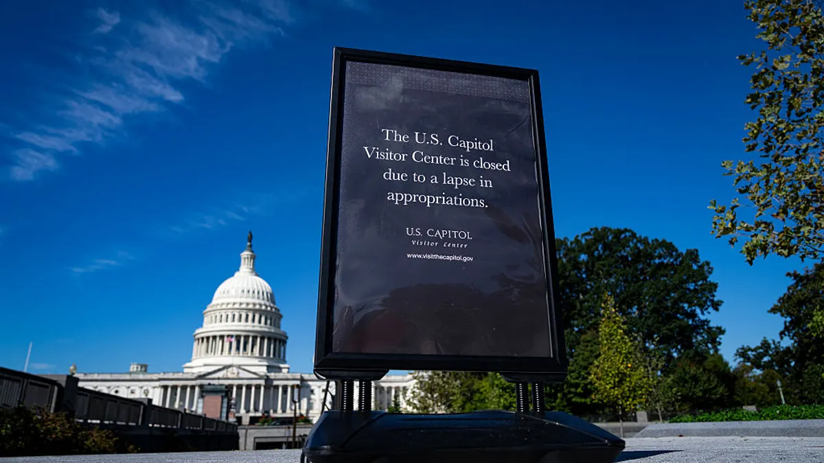 A sign notes that the U.S. Capitol Visitor Center is closed due to the government shutdown, with the capitol building in the background.