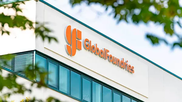 An orange GlobalFoundries logo above windows on a beige building.