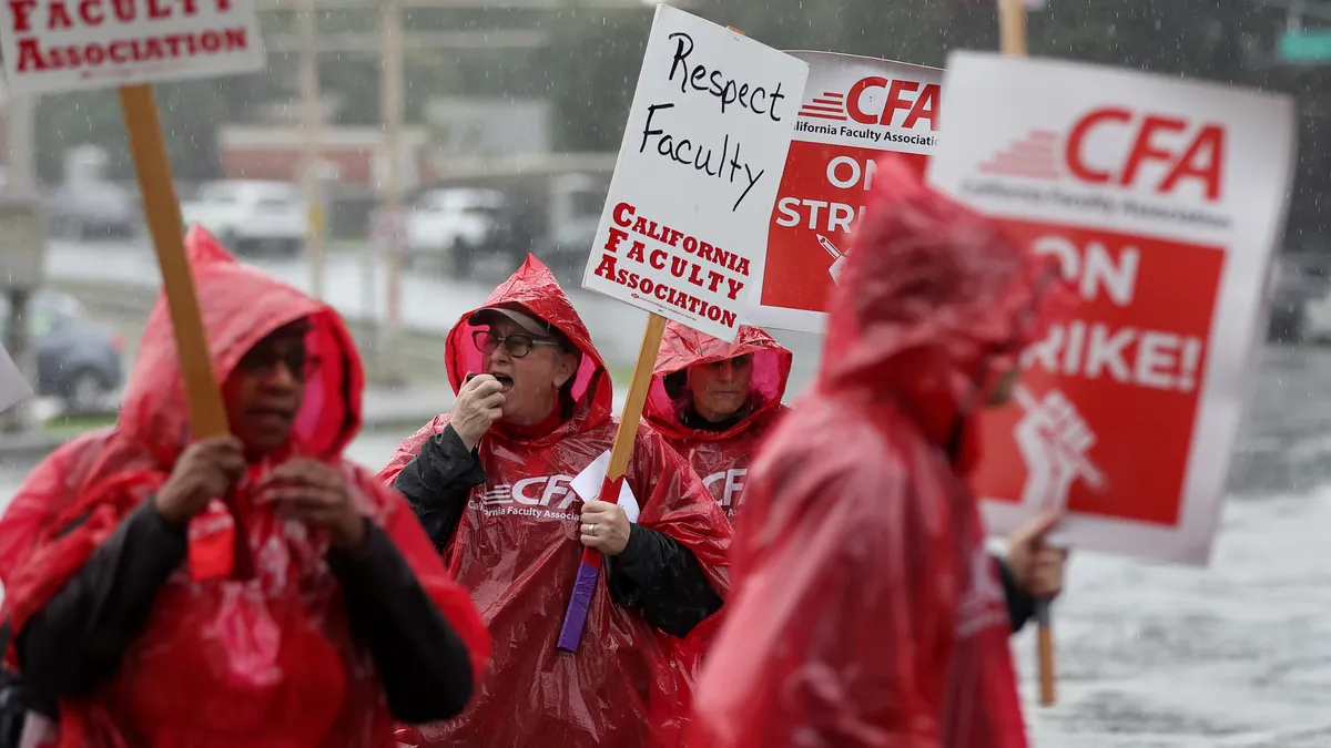 A group of people in red ponchos picket in the rain.