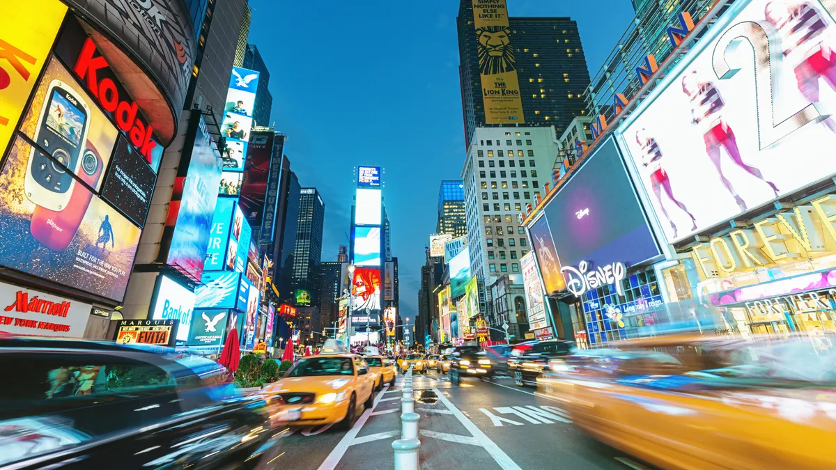 Crowded Times Square with people and taxi, car and cab traffic