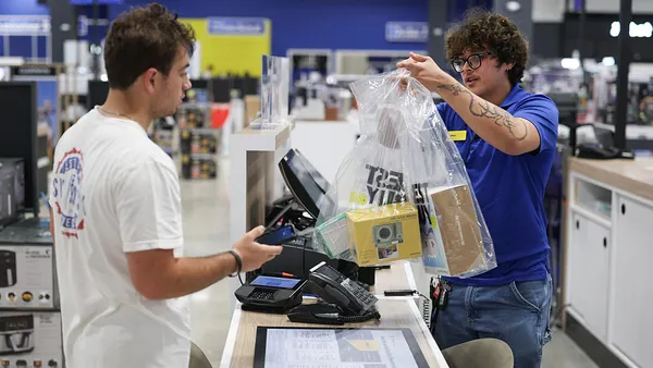 A Best Buy associate rings up a sale for a customer.