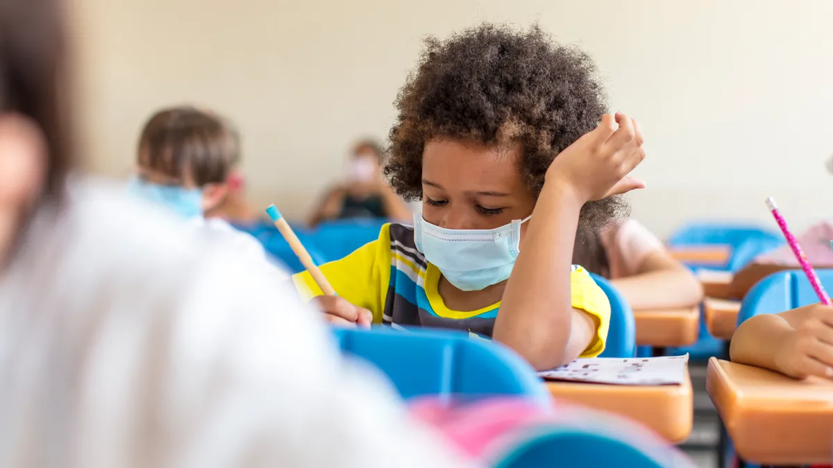 school boy wearing mask and study in classroom