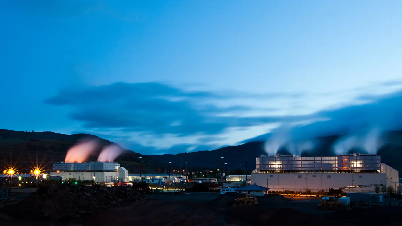 Plumes of steam rise from data center buildings.