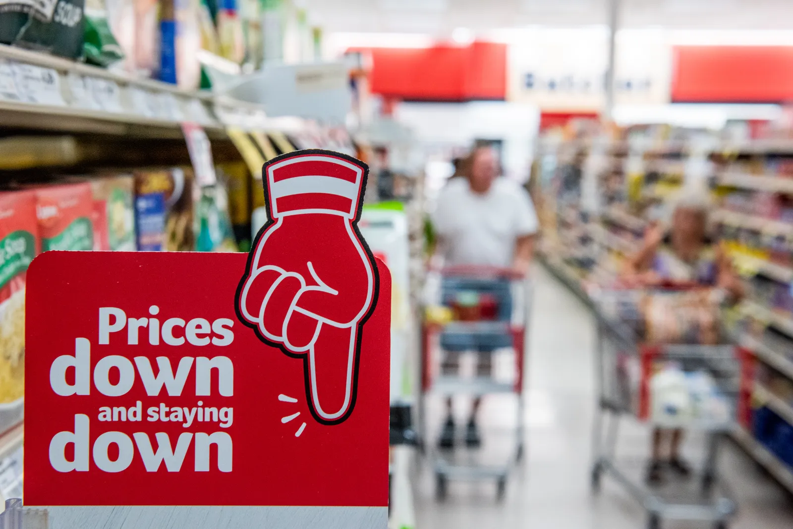 Close-up of a red sign that says "Prices down and staying down."