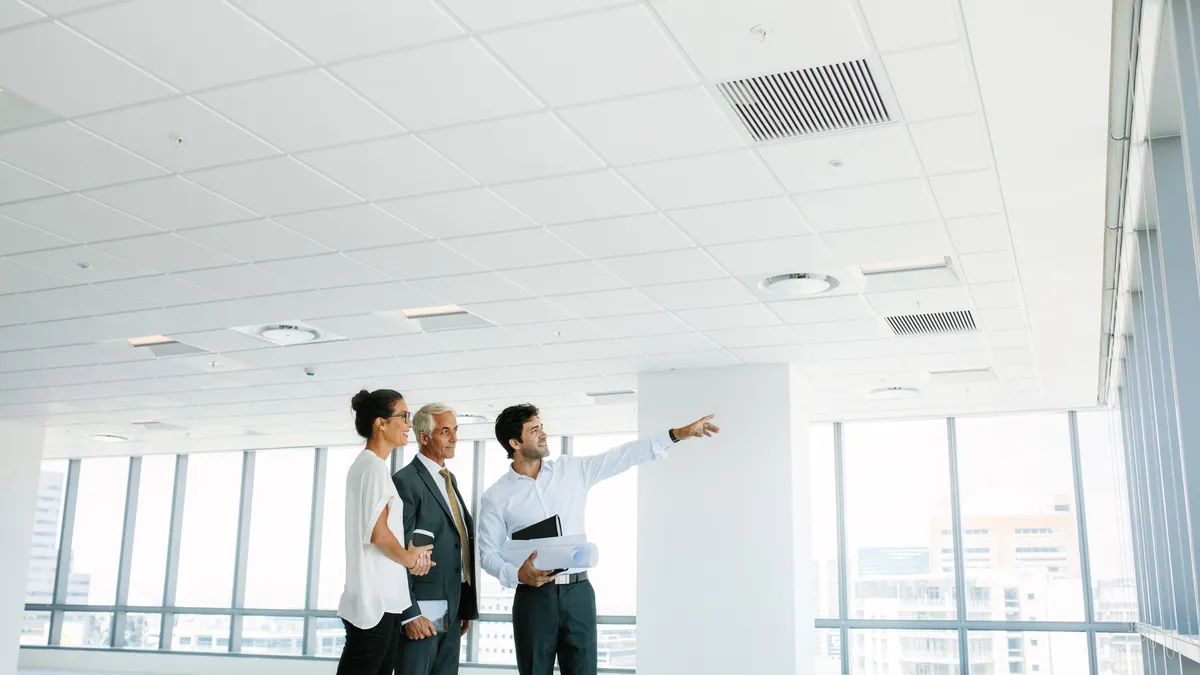 A real estate broker showing empty office space to clients.