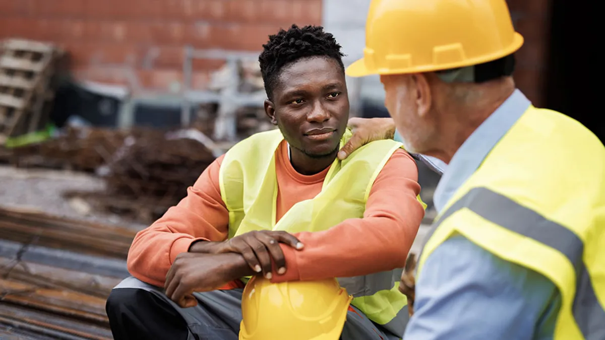 Photo of two construction workers taking a break at a construction site