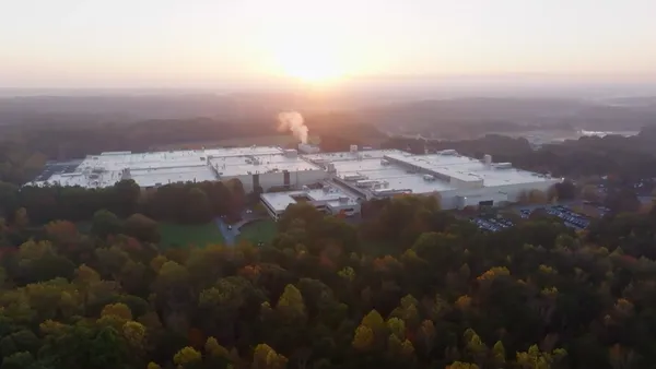 A drone photo of a factory set in a wooded countryside.