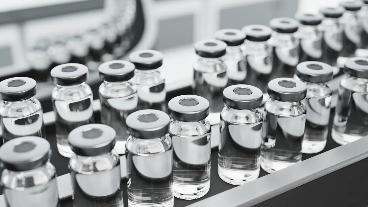 Vaccine vials on a production line in a pharmaceutical factory.