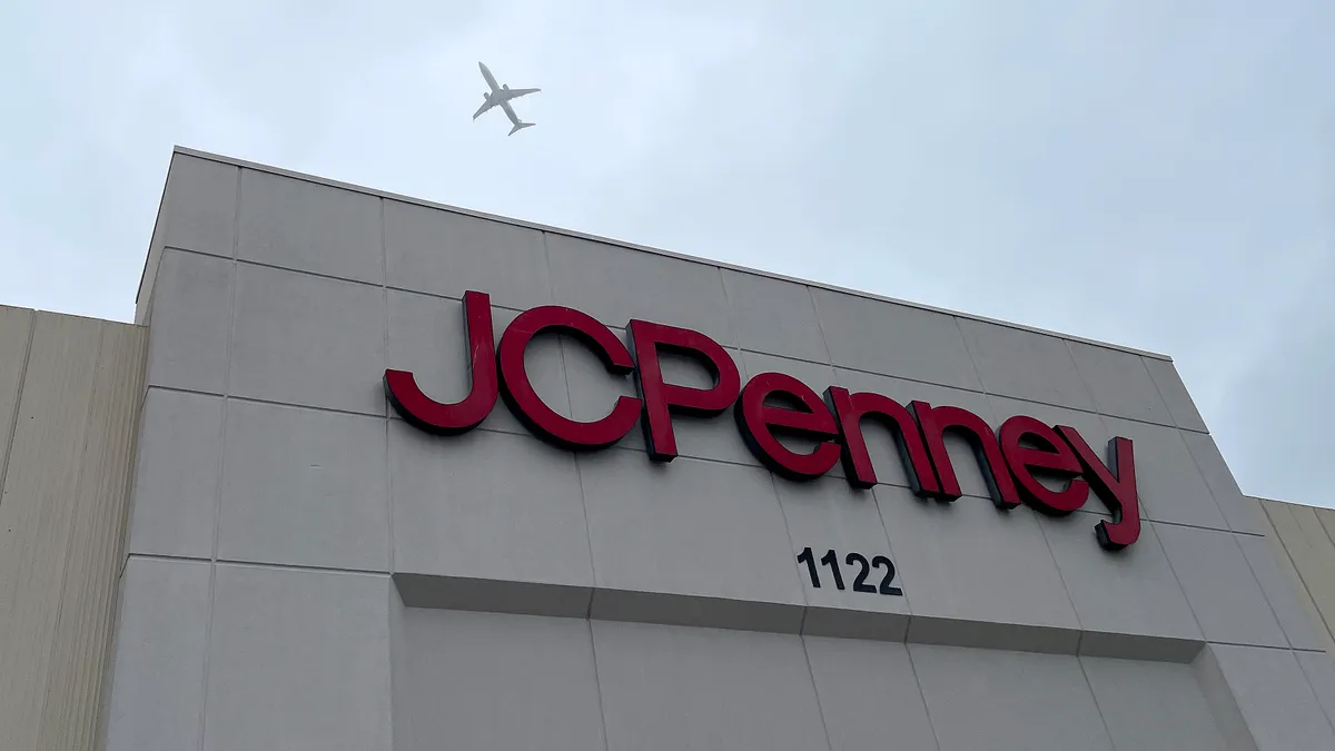 A plane flys over a J.C. Penney storefront.