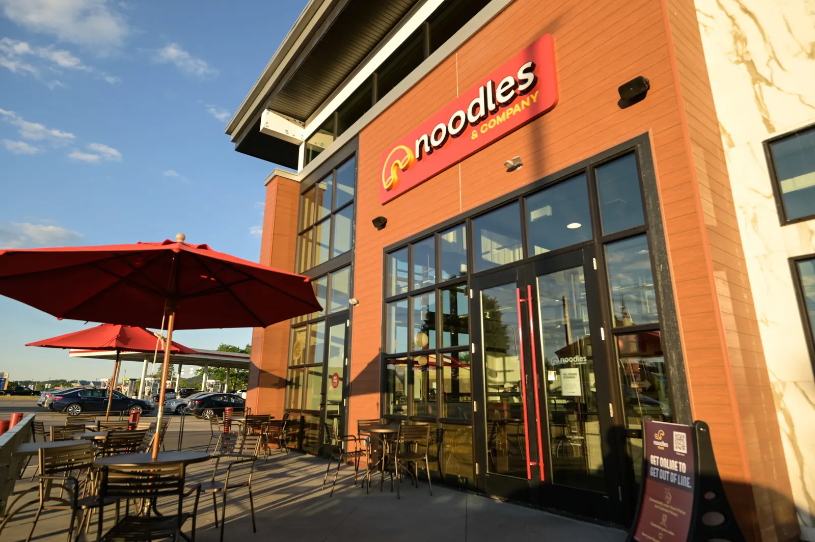 An image of a Noodles & Company restaurant with outdoor seating