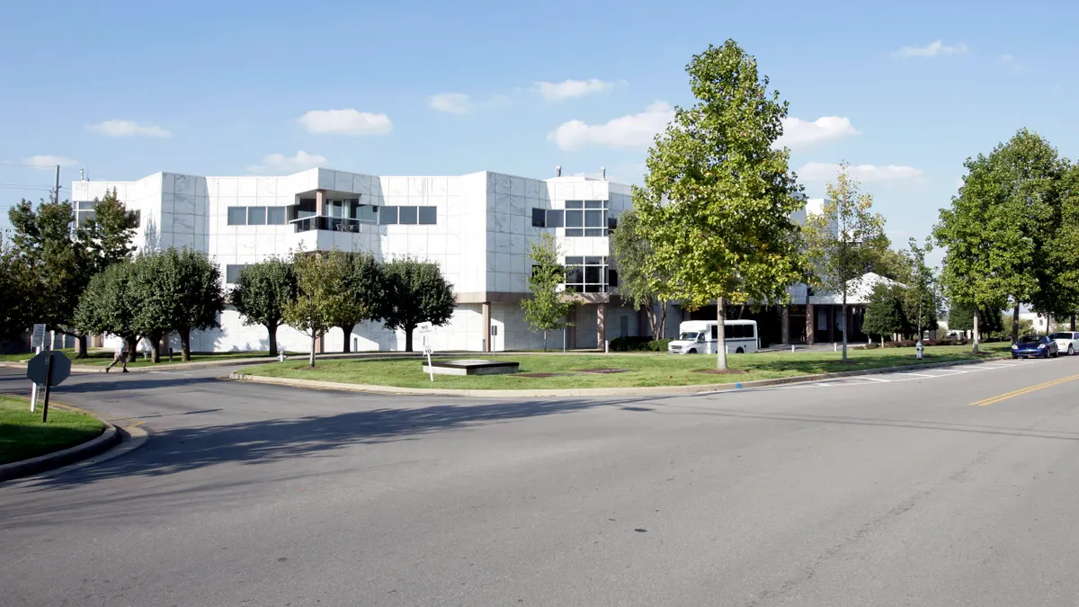 HCA's headquarters is a white, multi-story building on a grassy lawn.