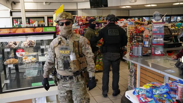 Federal agents walk through a gas station's store.