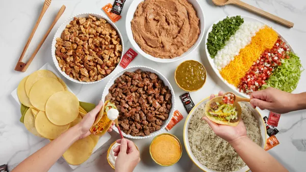 An image of different bowls with foods and hands making tacos.