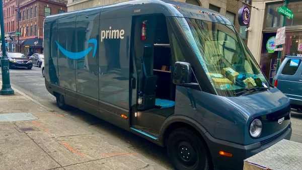 A delivery van, door open, parked on a city street.