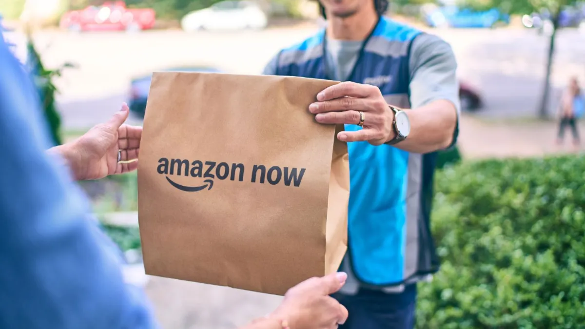 A person hands over a package labeled "Amazon Now."
