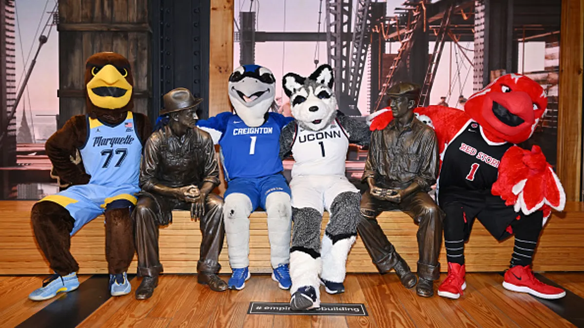 A group of mascots sit on a bench
