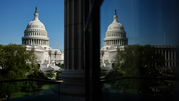 The facade of the Capitol building is reflected on windows across from it