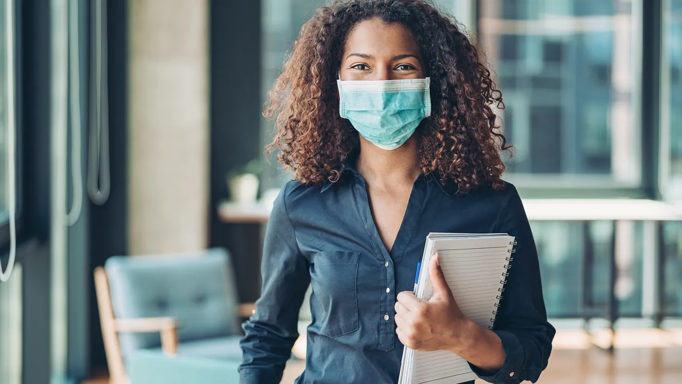 Young business woman with face mask in the office.