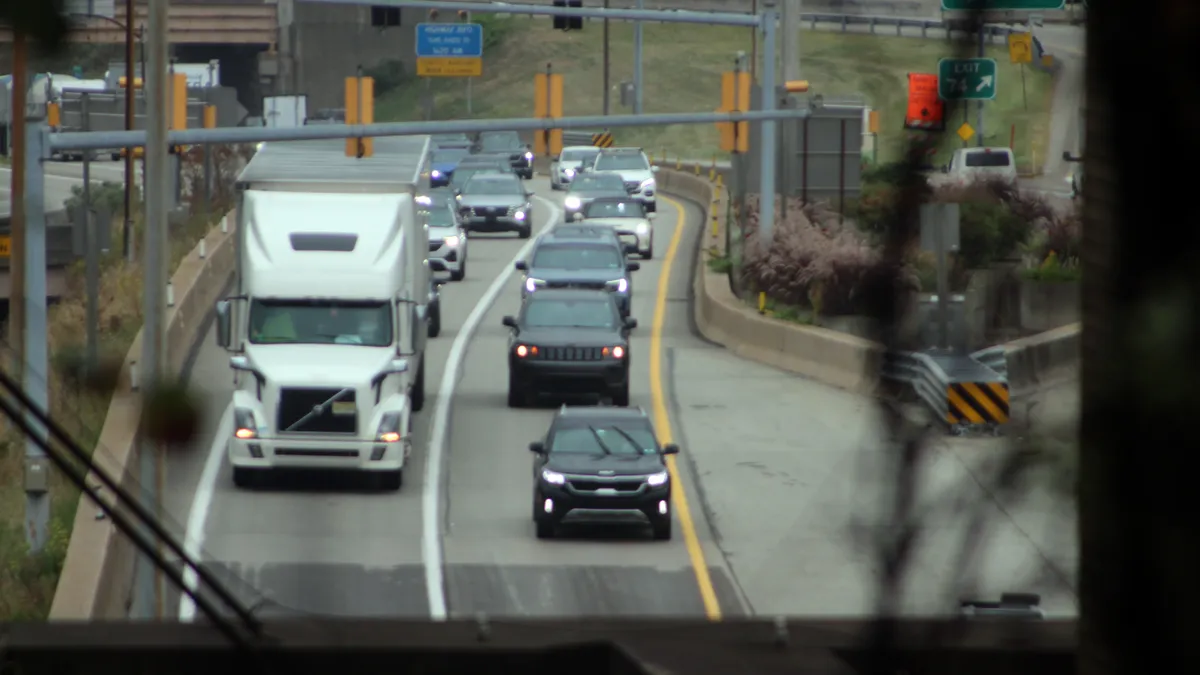 Traffic enters a tunnel in Pittsburgh going eastbound on I-376, with passenger vehicles surrounding a tractor-trailer.