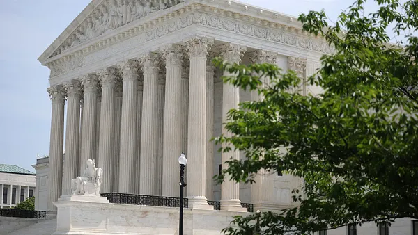 The Supreme Court with green tree branches in the foreground.