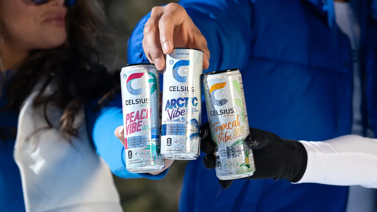 Three people hold cans of Celsius