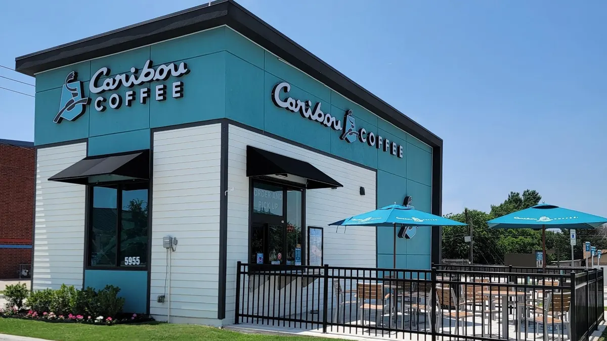 A photograph of a turquoise building with "Caribou Coffee" on the outside signage.