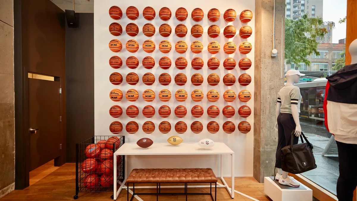 A wall with several rows of basketballs inside a Wilson Sporting Goods store in New York City.