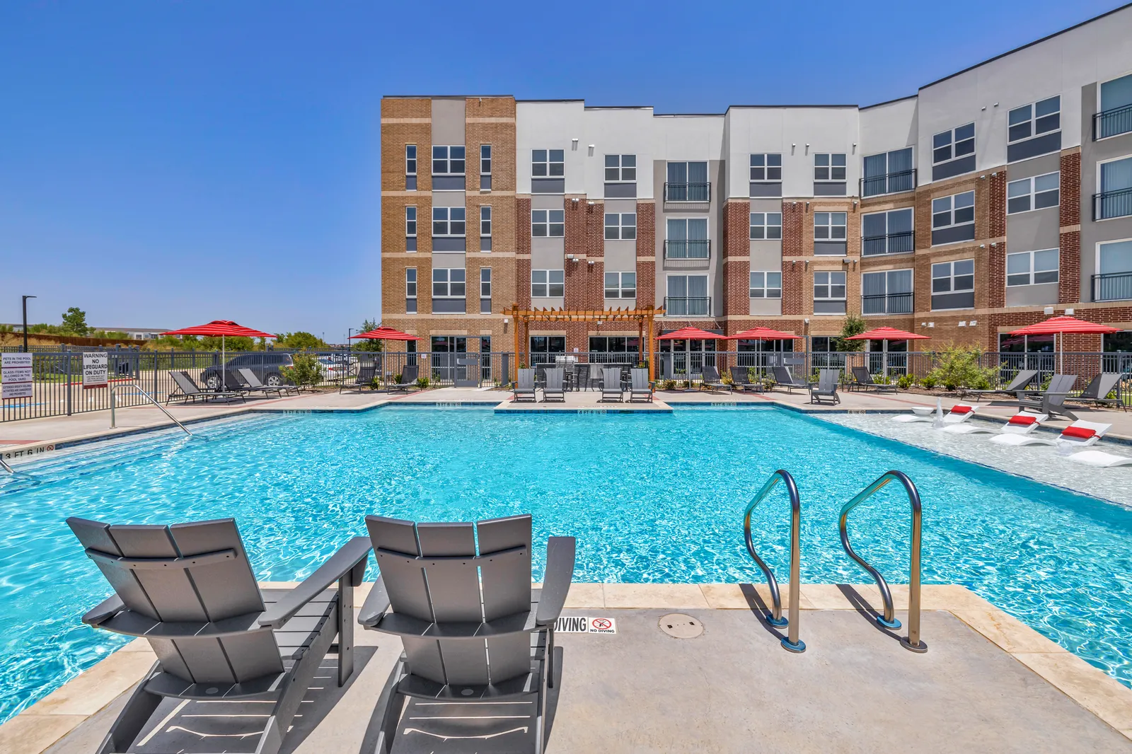 A pool area with a four-story building in the background.