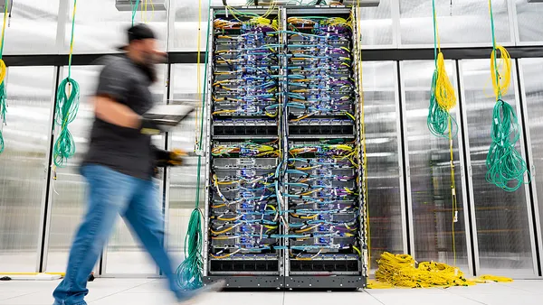 An Amazon Web Services technician passes on a AWS UltraServer in Austin, Texas on October 2, 2025