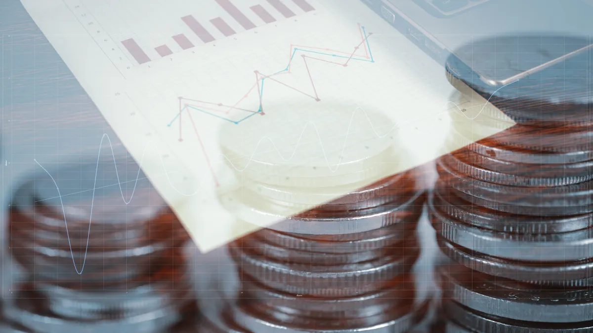 Double exposure of coin stack and notebook laptop computer with financial graph on white paper business planning vision and finance analysis concept