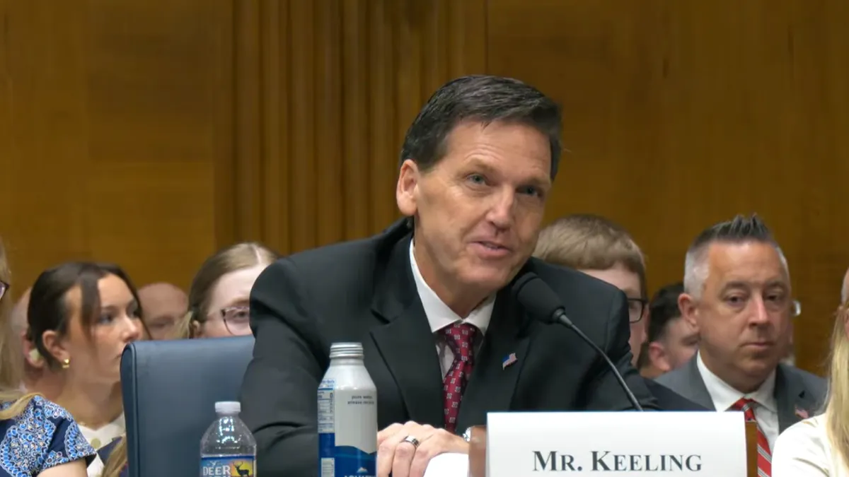 A screenshot of David Keeling speaking at a podium