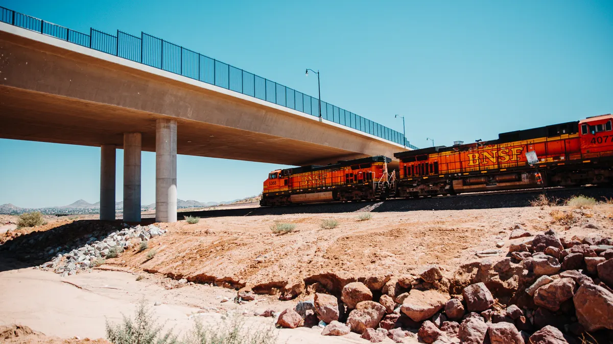 a train going under an elevated roadway