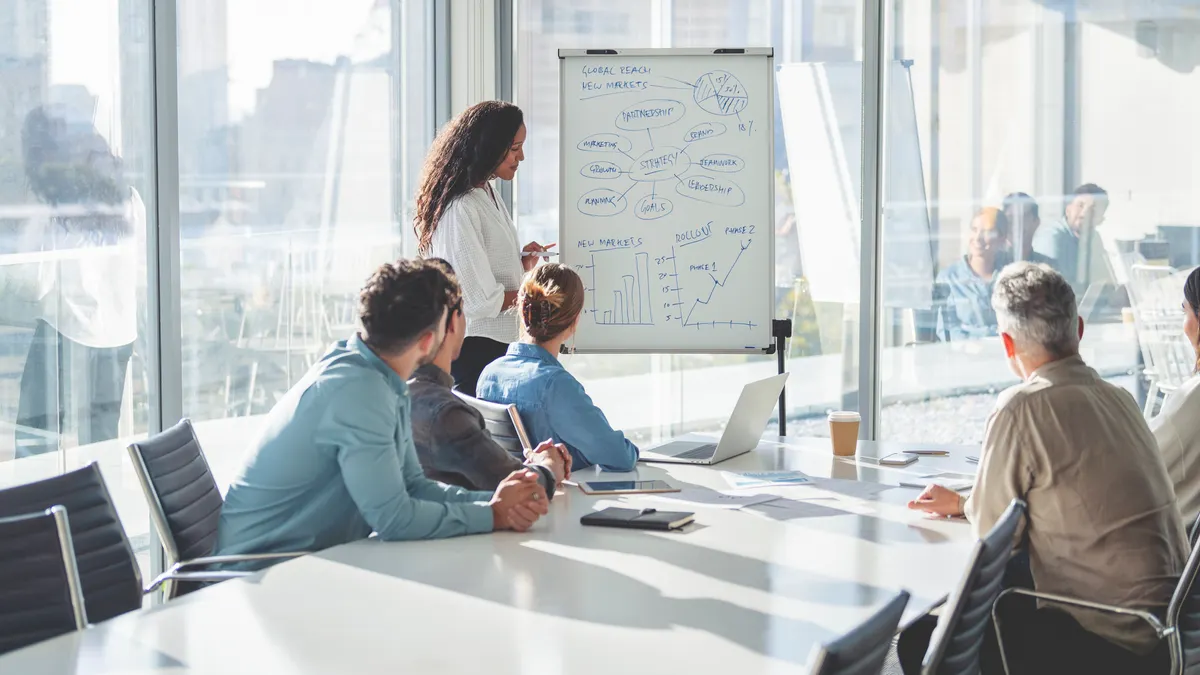 Business people watching a presentation on the whiteboard.