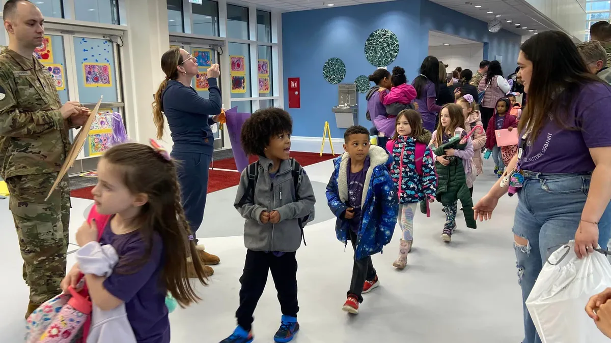 Elementary students walk through a school hallway