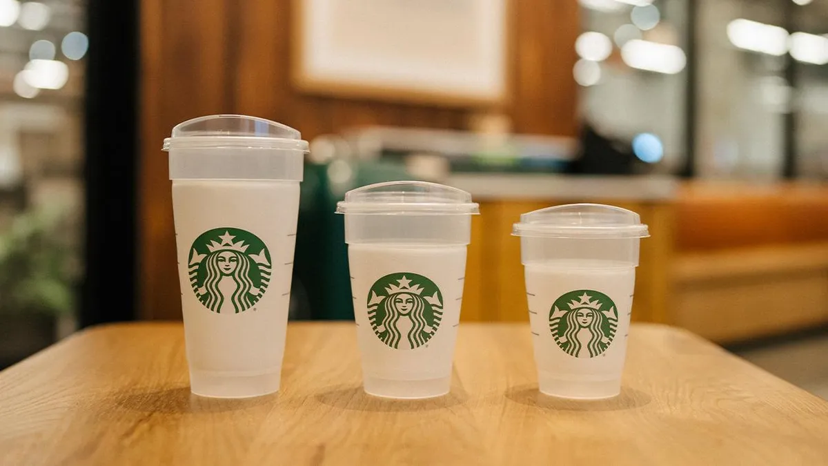 Three sizes of plastic cups with the green Starbucks logo and plastic lids.