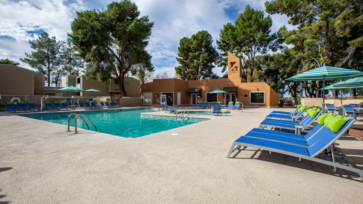 pool and chairs with apartments in the distant