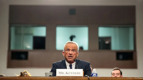 Robert F. Kennedy Jr. sits behind a desk in a Senate hearing room.