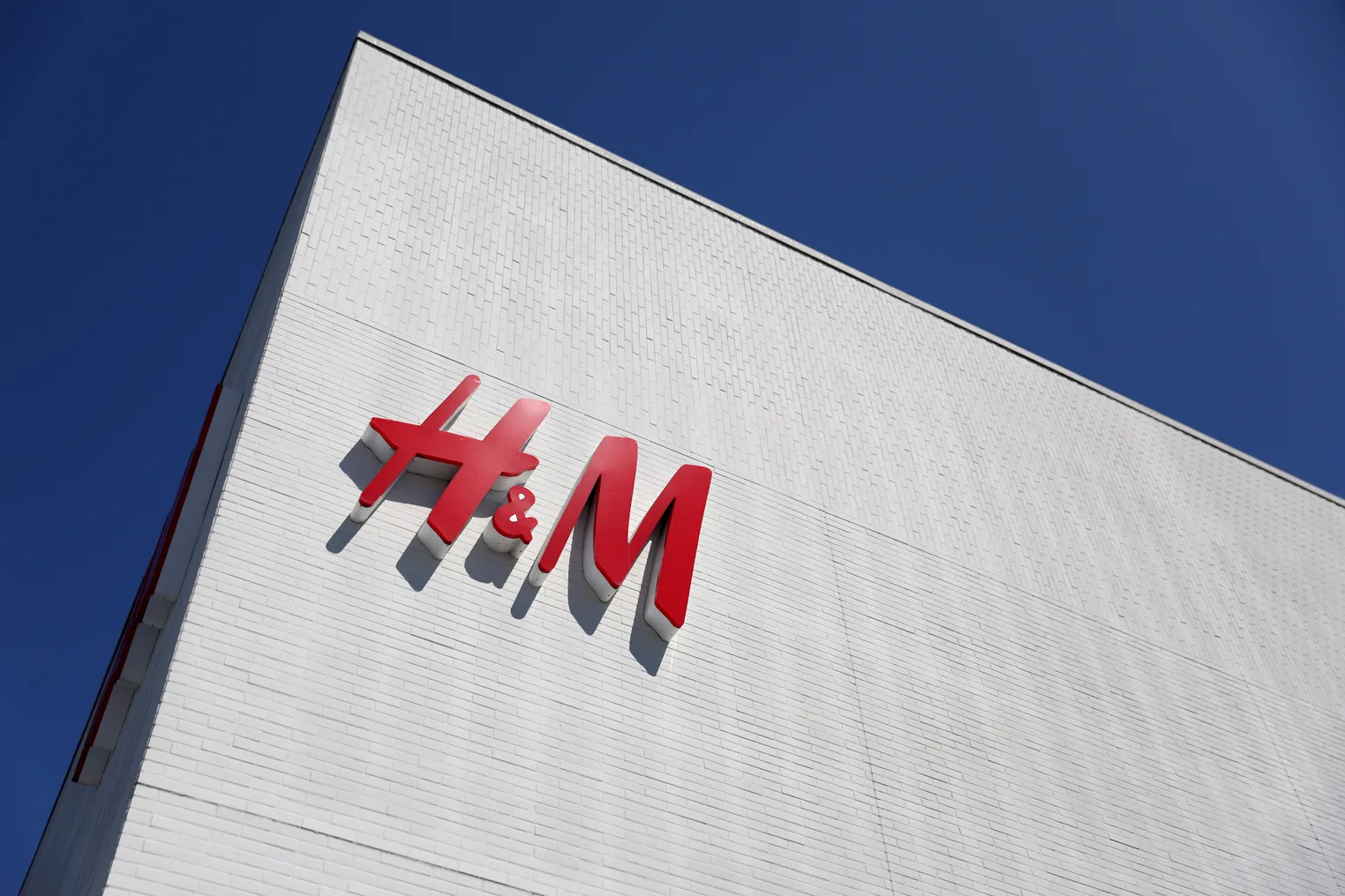 H&M's logo is pictured on a sign on a building.