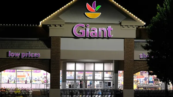 Exterior of a grocery store at night with a sign that reads "Giant"