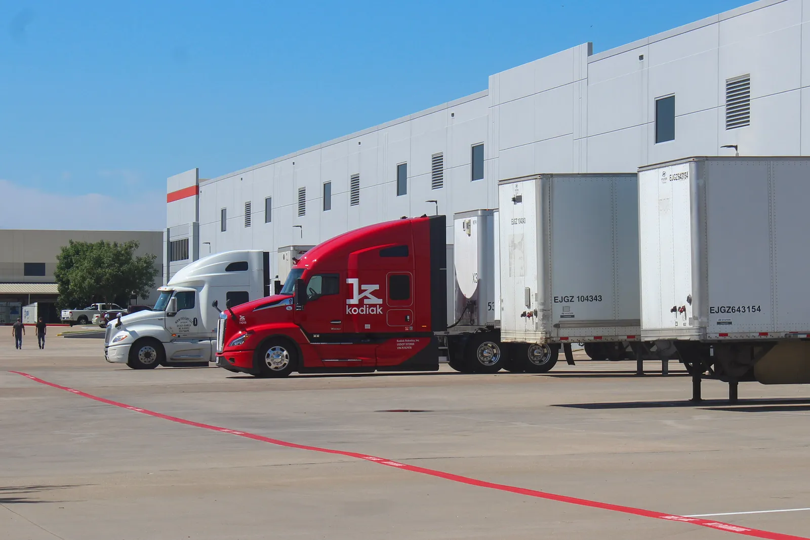 A red Kodiak truck is parked next to other tractor-trailers at an office park where the company&#x27;s Lancaster terminal is.