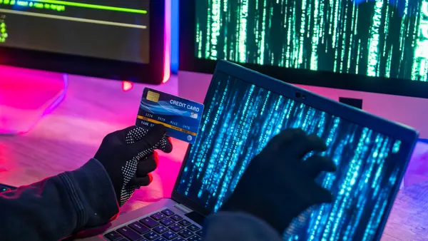 Hacker Using Laptop and Credit Card for Cybercrime Activities