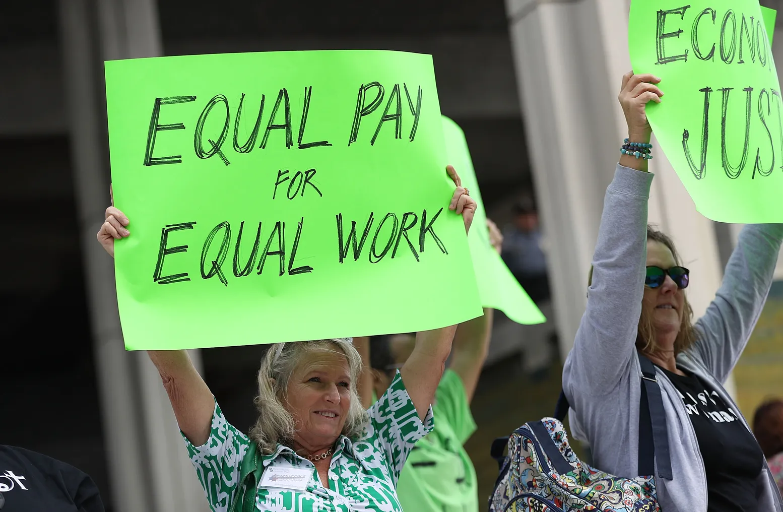 A protester holds up a sign that says "equal pay for equal work."