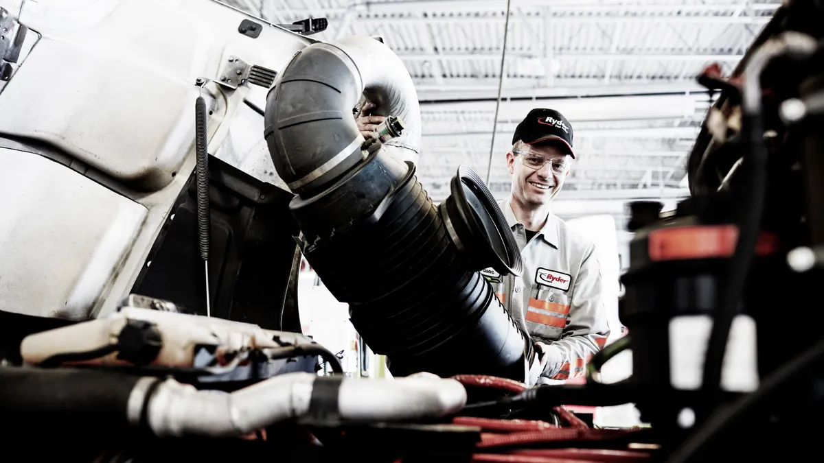 A Ryder employee works on a vehicle.