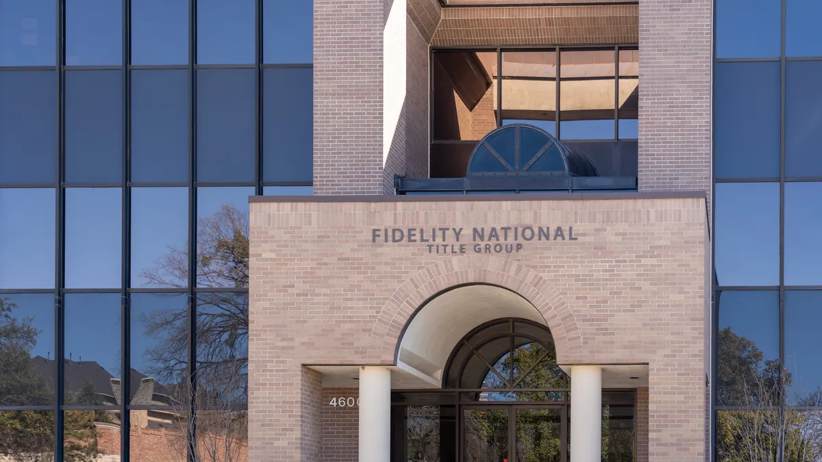 A picture of a glass office building with a brick entrance.