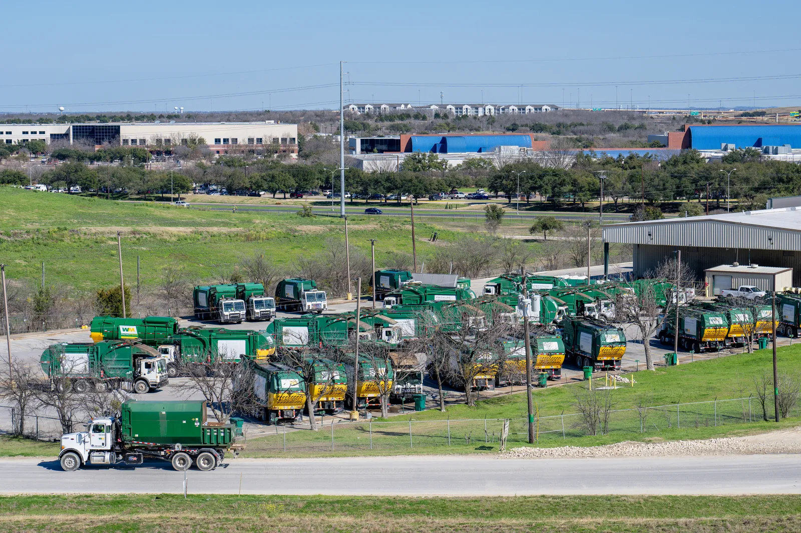 Trucks line up behind a waste facility