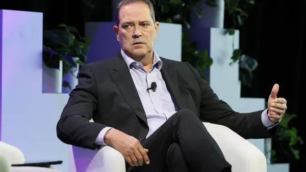 a man sitting on a white chair gesticulating